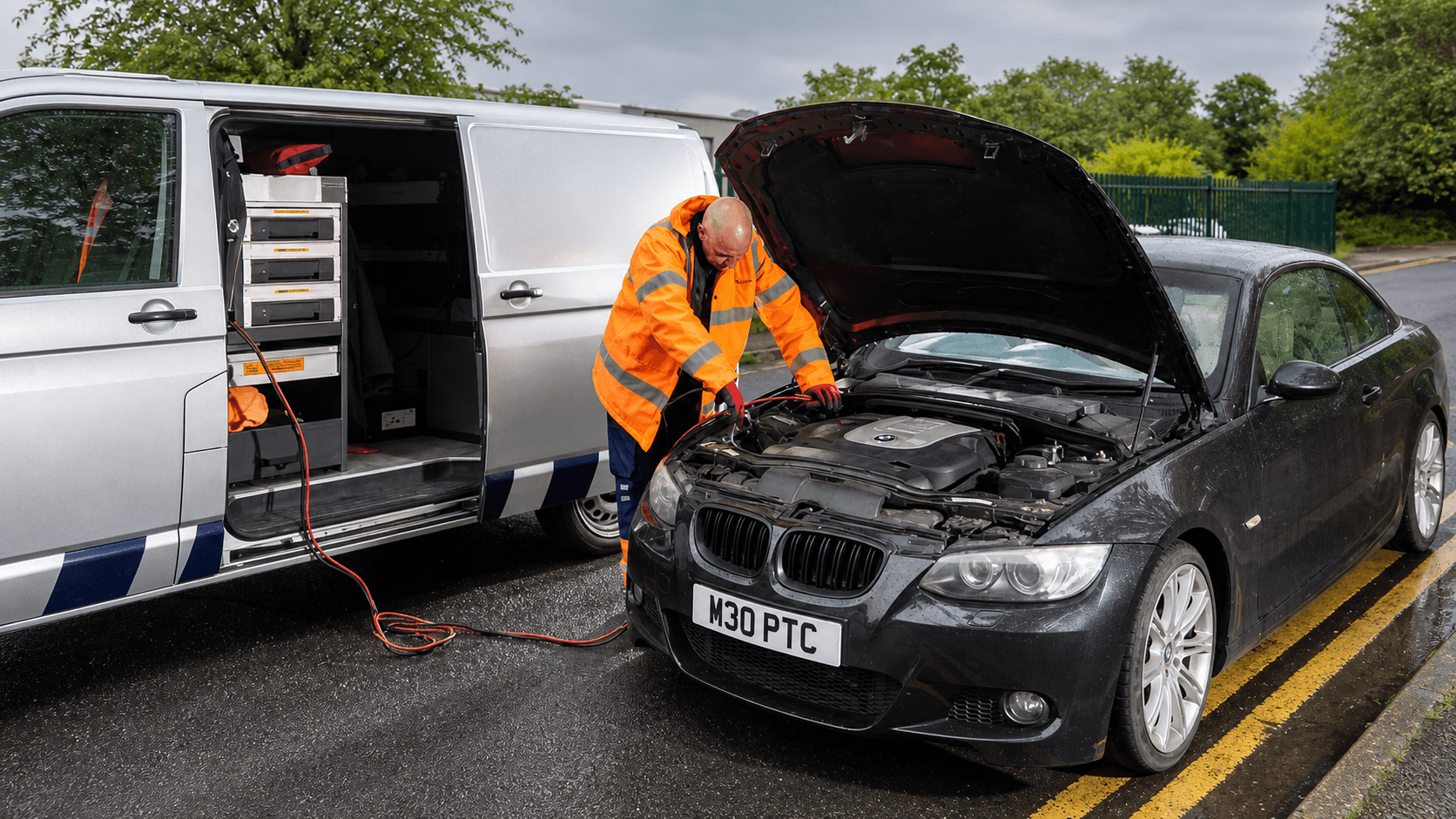 Roadside recovery technician assisting a black vehicle
